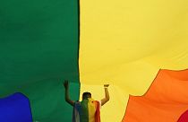 A participant holds up a large rainbow flag during the annual LGBT pride march in Belgrade, Serbia, Sept. 18, 2021. 