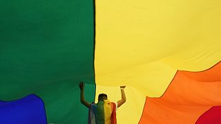A participant holds up a large rainbow flag during the annual LGBT pride march in Belgrade, Serbia, Sept. 18, 2021. 
