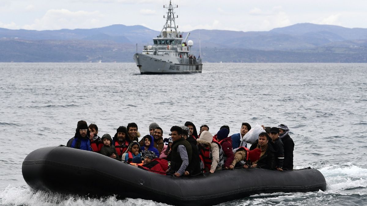 Migrants arrive with a dinghy accompanied by a Frontex vessel at the village of Skala Sikaminias, on the Greek island of Lesbos, on Feb. 28, 2020.