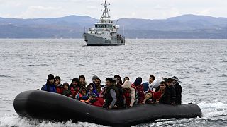 Des migrants arrivent sur un canot pneumatique accompagné d'un navire Frontex sur l'île grecque de Lesbos, le 28 février 2020.