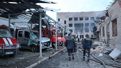 رجال الإنقاذ الأوكرانيون يمشون بالقرب من شاحنات خدمة الطوارئ المتضررة بجوار محطة إطفاء مدمرة بعد غارة في مدينة دنيبرو بشرق أوكرانيا، 22 ماي/أيار 2023