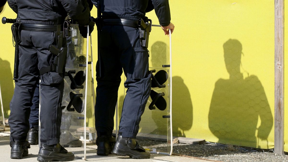 FILE: Austrian police cast shadows when practicing the protection of the border fence, Austria, Tuesday, June 26, 2018.