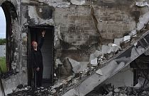 Eine Frau vor einem zerstörten Gebetshaus in der ukrainischen Stadt Orihiv