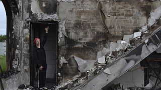 Eine Frau vor einem zerstörten Gebetshaus in der ukrainischen Stadt Orihiv