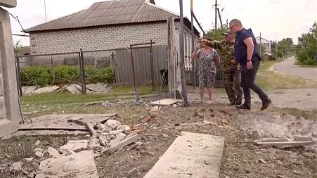 This image taken from a video shows people indicating a damaged building in the Belgorod region, Russia, Monday, May 22, 2023