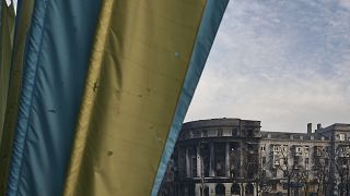 Украинский флаг на фоне разрушенного здания в Бахмуте. 10 февраля 2023 года