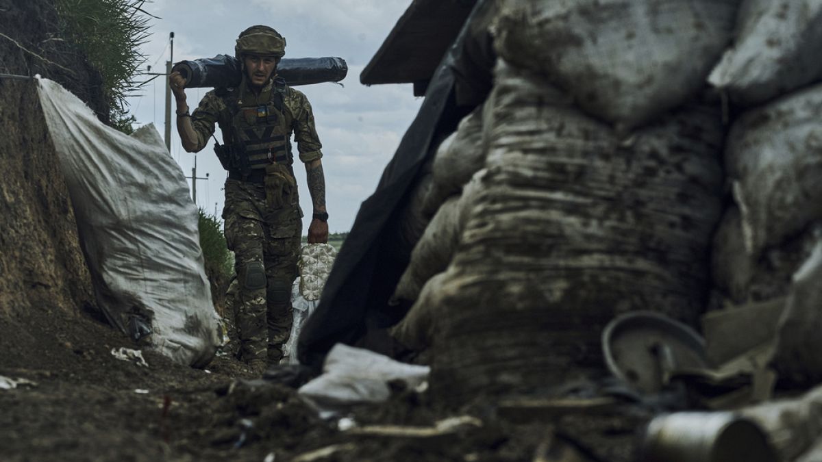 An Ukrainian soldier carries supplies in a trench at the frontline near Bakhmut in the Donetsk region, Ukraine, May 22, 2023