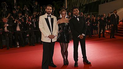 El director Sam Levinson con Lily-Rose Depp y Abel Tesfaye en la alfombra roja de Cannes