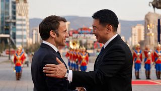 Mongolian President Ukhnaagiin Khürelsükh welcomes French President Emmanuel Macron upon his arrival at the government palace in Ulaanbaatar on May 21, 2023.