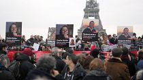 People hold portraits of French hostages in Iran Cecile Kohler, left, and Benjamin Briere during a protest in Paris, Saturday, Jan. 28, 2023. 