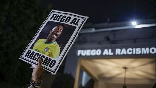 Um manifestante segura uma imagem de Vinicius Junior durante um protesto contra o racismo sofrido pelo avançado do Real Madrid durante uma partida contra o Valência