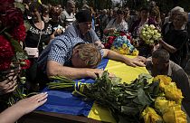 Parents cry over the coffin of their son Andrii Konyaev, a member of the Azov regiment defending Mariupol.
