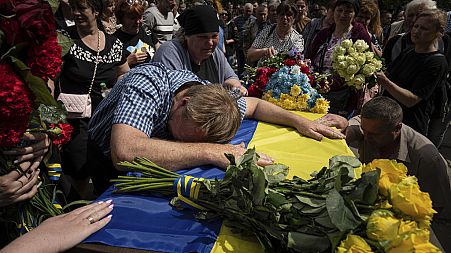 Parents cry over the coffin of their son Andrii Konyaev, a member of the Azov regiment defending Mariupol.