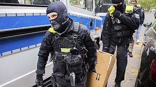 Des policiers transportent un carton vers un véhicule lors d'un raid à Berlin, Allemagne, mercredi 24 mai 2023. Christoph Soeder/dpa via AP