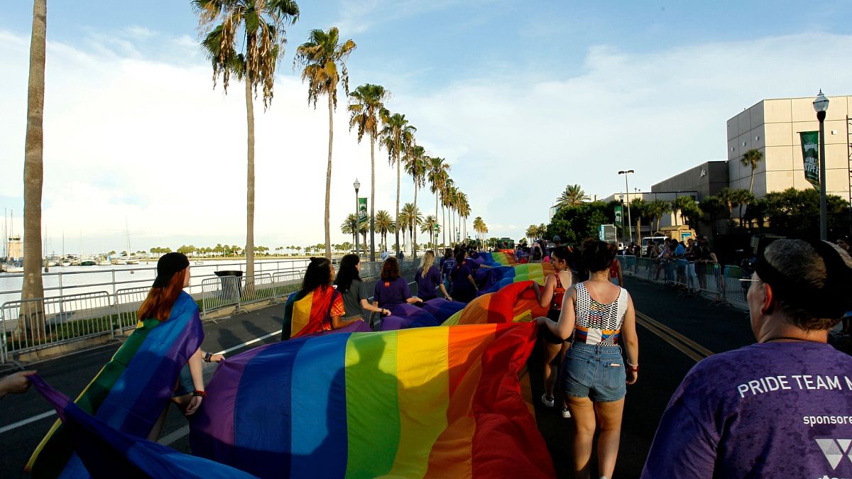 n this Saturday, June 24, 2017, file photo, volunteers lead a large rainbow banner during a gay pride parade in St. Petersburg, Florida.
