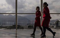Cathay Pacific Airways employees walk through the departures hall of Hong Kong International Airport in March 2023.