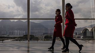 Cathay Pacific Airways employees walk through the departures hall of Hong Kong International Airport in March 2023.