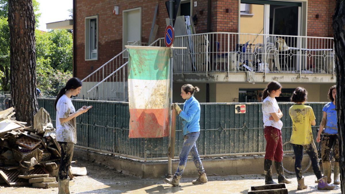 Voluntários limpam ruas de Itália após as cheias