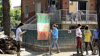 Voluntários limpam ruas de Itália após as cheias