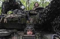 Soldados ucranianos en un tanque miran mientras recorren la carretera hacia sus posiciones cerca de Bakhmut, región de Donetsk, Ucrania, martes 23 de mayo de 2023