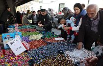 Compradores compram doces em banca de mercado no distrito histórico de Ulus, em Ancara, a 19 de abril de 2023.