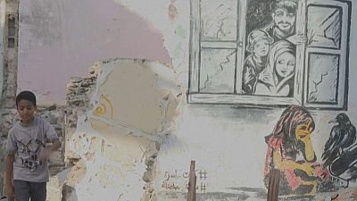 Una obra de Alaa Rubil en la pared de una casa destruida en Adén