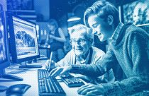 An illustration of a young IT expert helping an elderly person use the computer