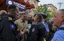 Aleksandar Arsenijevic, político local, habla con agentes de policía en la ciudad de Zvecan, Kosovo, el viernes 26 de mayo de 2023