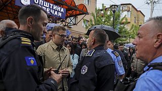 Aleksandar Arsenijevic, político local, habla con agentes de policía en la ciudad de Zvecan, Kosovo, el viernes 26 de mayo de 2023