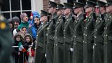 Members of the public wait for the President of Ireland Michael D. Higgins to inspect the Irish defense forces guard of honour at Dublin Castle, Ireland, Friday Jan. 1, 2016.