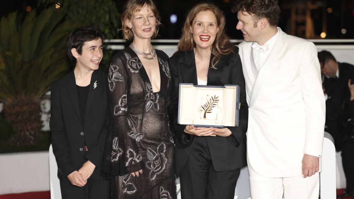 La regista Justine Triet regge la Palma d'Oro, insieme agli attori del suo film. (Cannes, 27.5.2023)