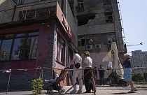 Περαστικοί μπροστά από κτίριο που δέχθηκε επίθεση με drone στο Κίεβο
