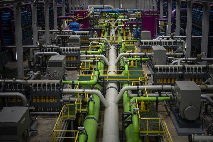 A worker walks over the pipeline that transports seawater to filters at Europe's largest desalination plant in Barcelona.