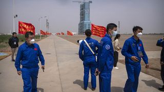 موظفون بالقرب من مركبة الفضاء شنجو-16 على منصة إطلاق في مركز جيوتشيوان لإطلاق الأقمار الصناعية في شمال غرب الصين