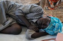 فتاة سودانية نازحة تنتظر عند معبر حدودي بين السودان وجنوب السودان