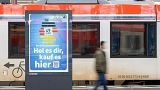 A man passes by an advertising for the Deutschlandticket (Germany Ticket) at a train station in Frankfurt, Germany, Monday, May 1, 2023. 