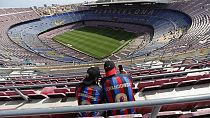 Two Barcelona fans wait for the start of a Spanish La Liga soccer match between Barcelona and Mallorca at the Camp Nou stadium in Barcelona