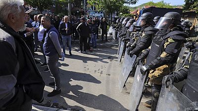 محتجون صربيون يقفون أمام قوات مكافحة الشغب