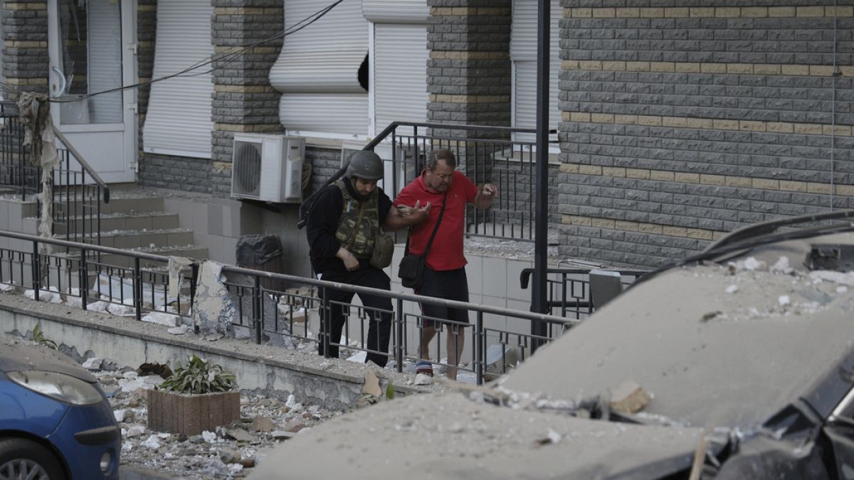 A resident being helped by a soldier in the aftermath of the attack in Kyiv.