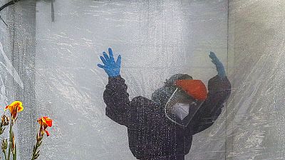 A health worker wearing a protective suit is disinfected in a portable tent outside the Gat Andres Bonifacio Memorial Medical Center in Manila, Philippines, on April 27, 2020.