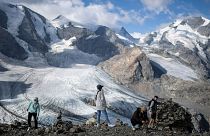 People stand in front of the Pers and Morteratsch glaciers in Pontresina, Switzerland. August 2022. 