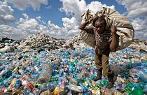 Kenya'nın başkenti Nairobi'de bir gecekondu mahallesinde geri dönüşüm için satmak üzere plastik atık toplayan bir vatandaş