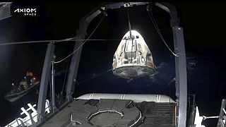 A mentőcsapatok kiemelik és rögzítik a SpaceX Dragon kapszulát, miután az a Mexikói-öbölben landolt, Florida Panhandle partjainál, 2023. május 30-án