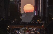 The sun sets as seen between buildings along 42nd Street in New York during a phenomenon known as Manhattanhenge, Tuesday, May 30, 2023.