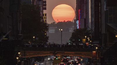 The sun sets as seen between buildings along 42nd Street in New York during a phenomenon known as Manhattanhenge, Tuesday, May 30, 2023.