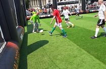 Fehér Csaba (pirosban) az ekkor épp a nemzetközi csapat hálóját őrző Király Gábornak (zöld mezben) lő gólt a Hősök terén felállított pályán 2023.05.31-én.