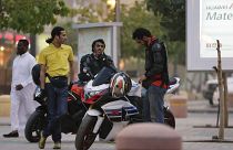  شبان سعوديون يقفون بجانب دراجاتهم النارية في أحد شوارع الرياض
