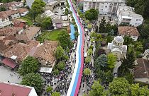 People hold a giant Serbian flag during a protest in the town of Zvecan, northern Kosovo, Wednesday, May 31, 2023. 