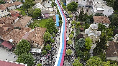 Manifestantes serbios sostienen una bandera serbia gigante durante una protesta en la ciudad de Zvecan, en el norte de Kósovo, el miércoles 31 de mayo de 2023. 