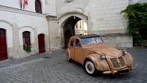 French cabinetmaker Michel Robillard driving his wooden 2CV Citroen car in the streets of Loches.